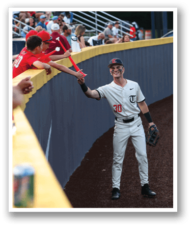 A baseball player wearing a white uniform is standing on the field, holding a bat. AI generated content