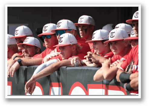 A group of baseball players wearing red jerseys and red hats are standing on a field. AI generated content