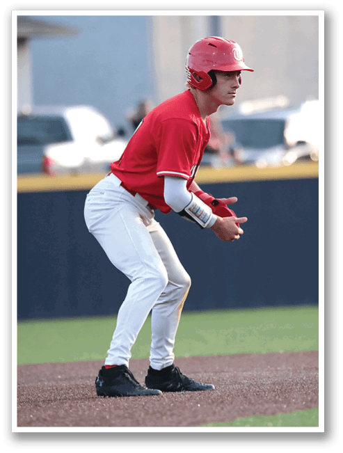 A baseball player in a red shirt and white pants is crouching down on the field, preparing to catch a ball. AI generated content