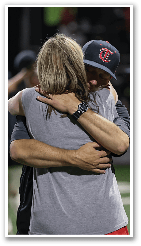 Two people hugging on a field. AI generated content