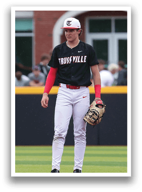 A baseball player in a black and red shirt and white pants stands on the field. AI generated content