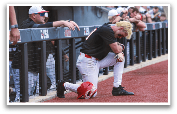 A baseball player is kneeling on the field, wearing a red helmet. AI generated content