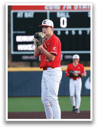 A baseball player in a red shirt and white pants stands on a field, holding a baseball glove. AI generated content