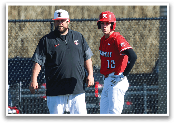 Two men are standing on a baseball field, one of them wearing a red shirt and the other wearing a black shirt. They are talking to each other. AI generated content