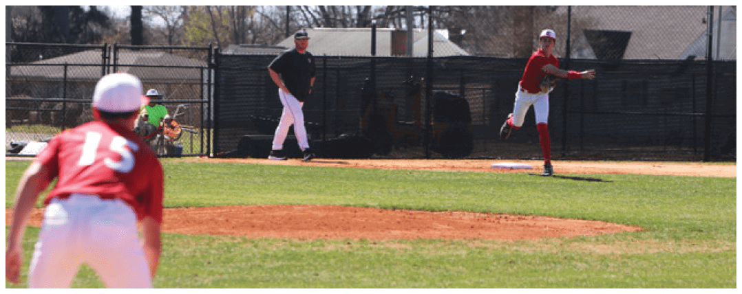 A baseball game is in progress with a player in a red uniform throwing a ball. AI generated content
