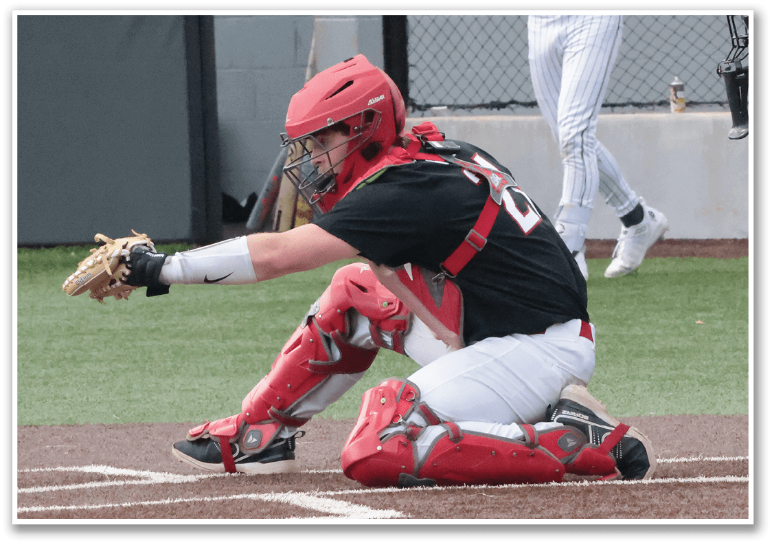 A baseball player is squatting on the ground wearing a red helmet and red pads. AI generated content