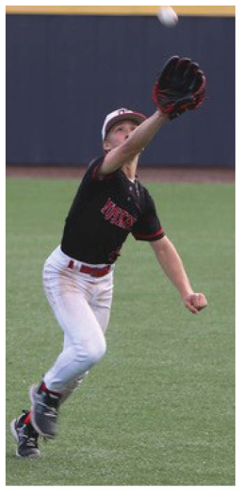 A baseball player in a black shirt and white pants is reaching out to catch a ball. AI generated content