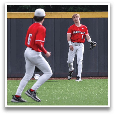 Two baseball players in red uniforms are running on a field. AI generated content