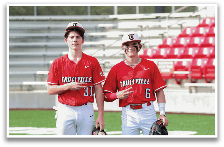 Two baseball players wearing red shirts and white pants stand on a field. AI generated content
