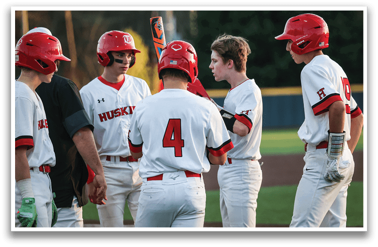 A group of baseball players wearing red helmets and white uniforms are standing on a field. AI generated content