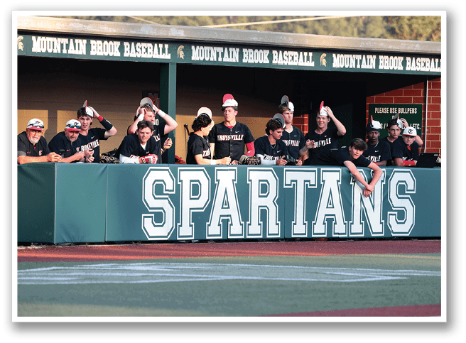 A group of people are sitting on a bench in front of a green banner that says “Spartans." AI generated content