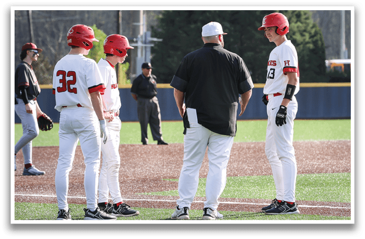Three baseball players wearing red helmets and white uniforms are standing on a baseball field. A man in a black shirt is talking to them. AI generated content