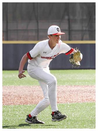 A baseball player in a white uniform is pitching a ball on a field. AI generated content