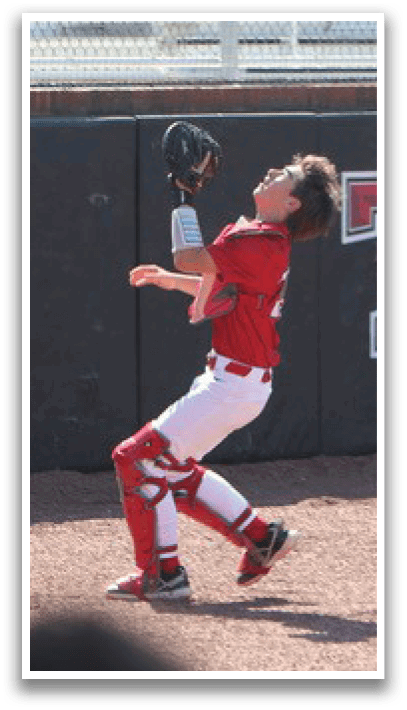 A baseball player in a red shirt and white pants is catching a ball. AI generated content