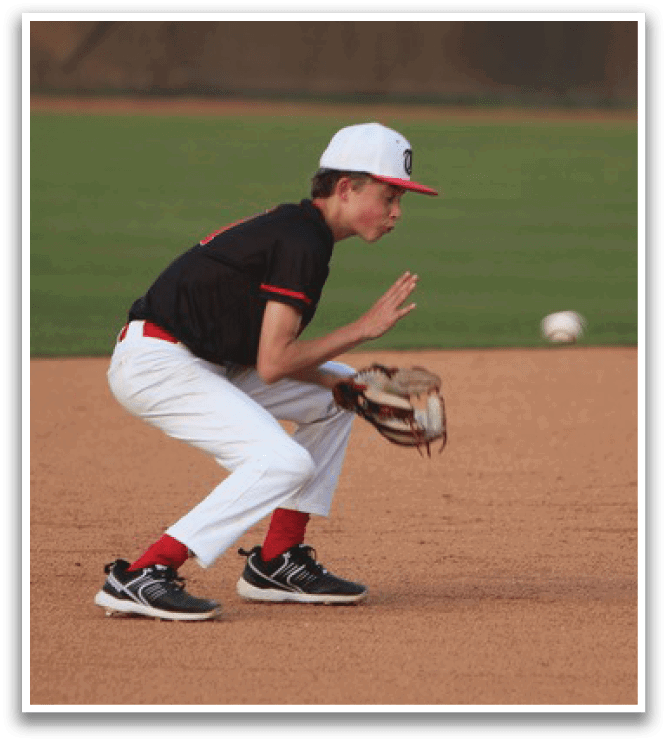 A baseball player in a black shirt and white pants is crouching down to catch a ball. AI generated content
