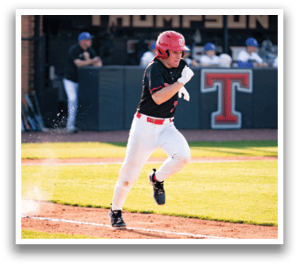A baseball player in a red helmet and black uniform is running towards first base. AI generated content