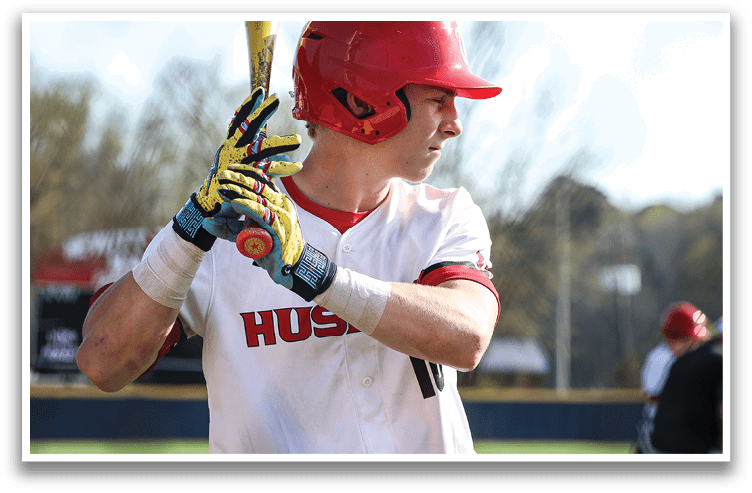 A baseball player in a red helmet and white uniform is holding a bat, preparing to swing. AI generated content