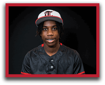 A young man wearing a black and white baseball uniform is sitting on a stool. AI generated content
