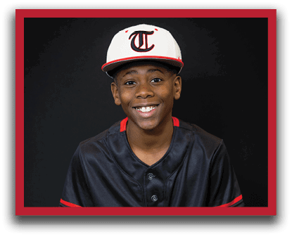 A young boy wearing a baseball uniform is sitting on a stool. AI generated content