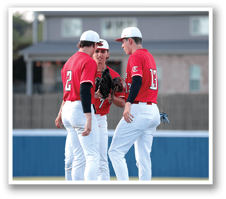 Three baseball players in red and white uniforms are standing on a field, talking to each other. AI generated content