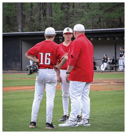 Three men wearing red shirts and white pants are standing on a baseball field. AI generated content