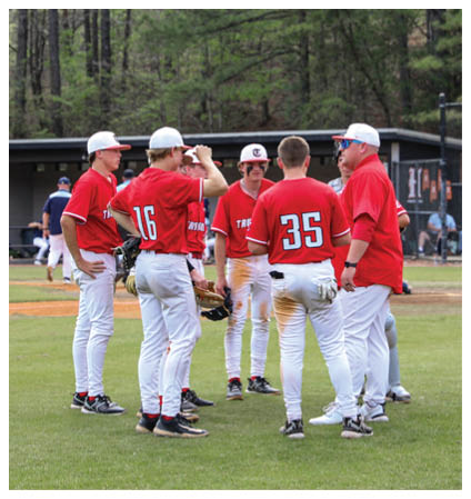 A group of baseball players wearing red shirts and white pants are standing on a field. AI generated content