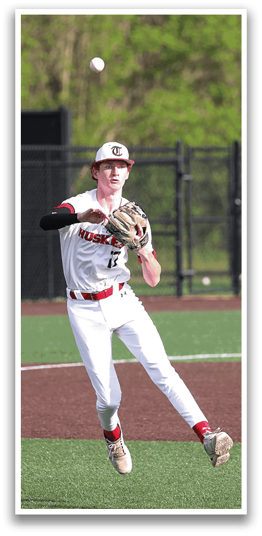 A baseball player wearing a white uniform is leaping in the air to catch a ball. AI generated content