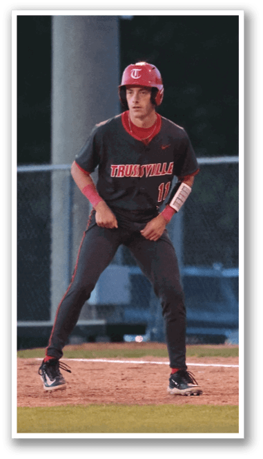 A baseball player wearing a red helmet and black uniform is standing on the field. AI generated content