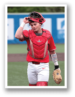 A baseball player wearing a red helmet and red chest protector. AI generated content