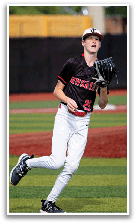 A baseball player wearing a black and red jersey and a catcher's mitt is running on the field. AI generated content