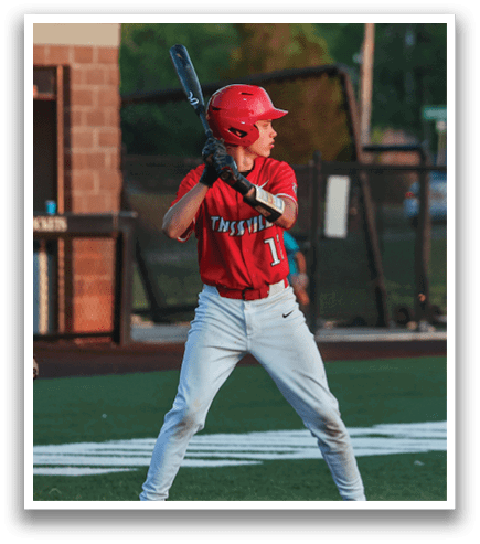 A baseball player in a red shirt and white pants is holding a bat, ready to swing. AI generated content