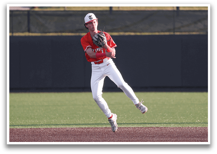 A baseball player in a red shirt and white pants is leaping in the air to catch a ball. AI generated content