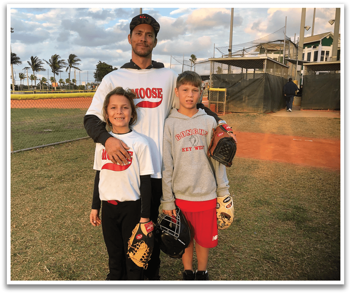 A man and two children pose for a picture on a baseball field. AI generated content