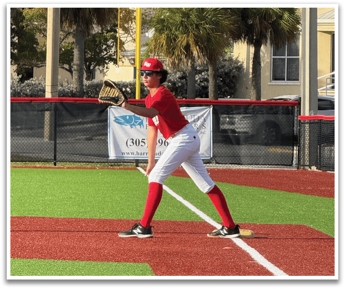 A baseball player in a red shirt and white pants is holding a baseball bat and standing on a baseball field. AI generated content