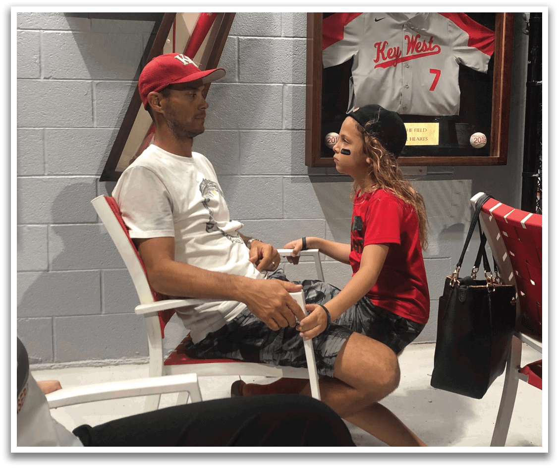 A man and woman are sitting in chairs, with the woman painting the man's fingernails. AI generated content