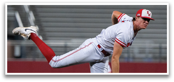 A baseball player in a white and red uniform is pitching a ball. Description generated by AI
