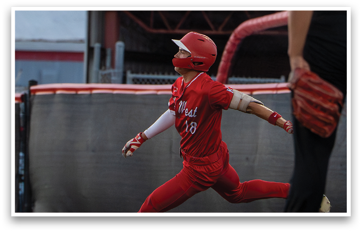 A baseball player in a red uniform running towards a base. Description generated by AI