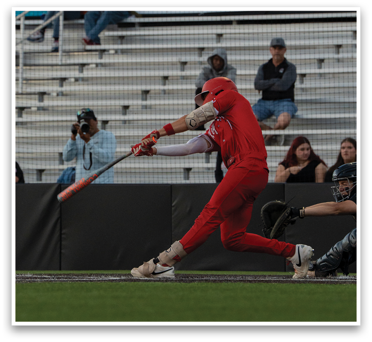 A baseball player in a red shirt and red pants swinging a bat. Description generated by AI