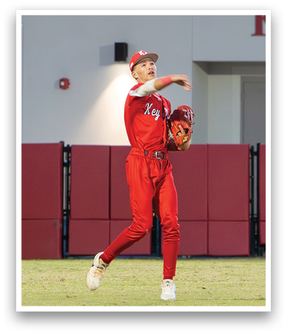 A baseball player wearing a red jersey and red pants is throwing a ball. Description generated by AI