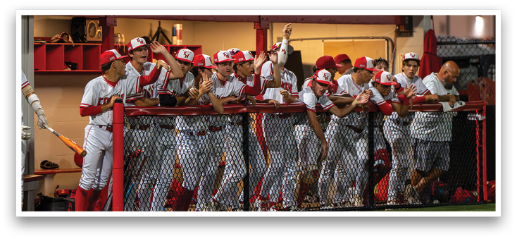 A group of baseball players wearing red and white uniforms. Description generated by AI