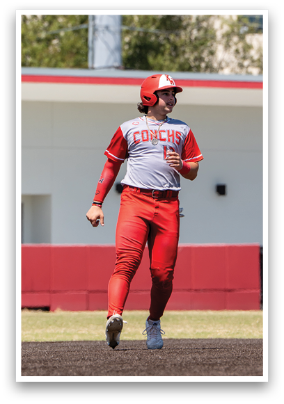 A baseball player wearing a red and white uniform is running on the field. Description generated by AI
