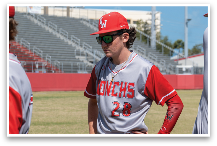 A baseball player wearing a red jersey with the number 28. Description generated by AI