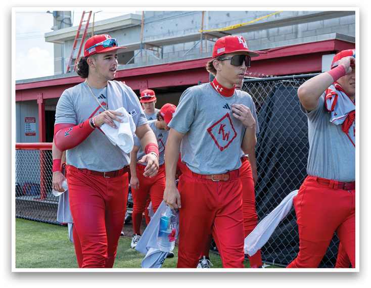 A group of baseball players walking on a field. Description generated by AI
