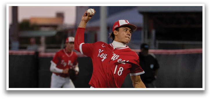 A baseball player in a red shirt and white pants is throwing a ball. Description generated by AI