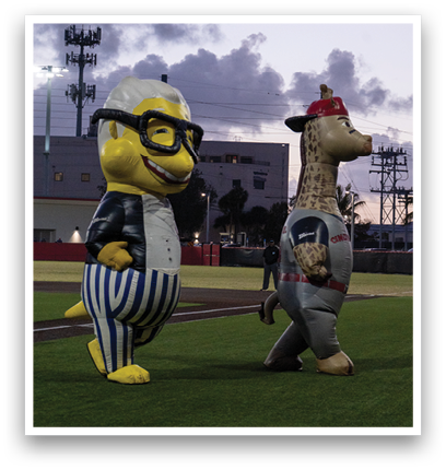 Two mascot statues are standing on a field. Description generated by AI