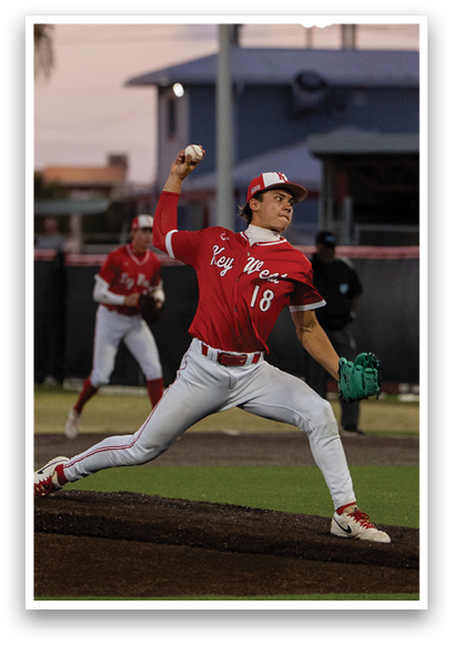 A baseball player in a red shirt and white pants is throwing a ball. Description generated by AI