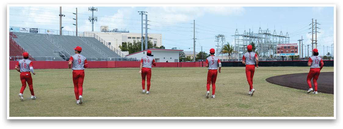A group of people wearing red and white uniforms are standing on a baseball field. Description generated by AI