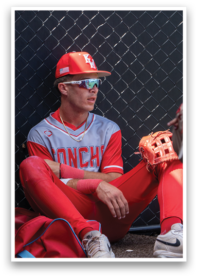 A baseball player wearing a red shirt and red pants. Description generated by AI