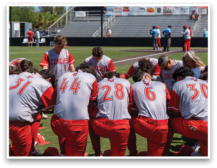 A group of baseball players kneeling on the field. Description generated by AI