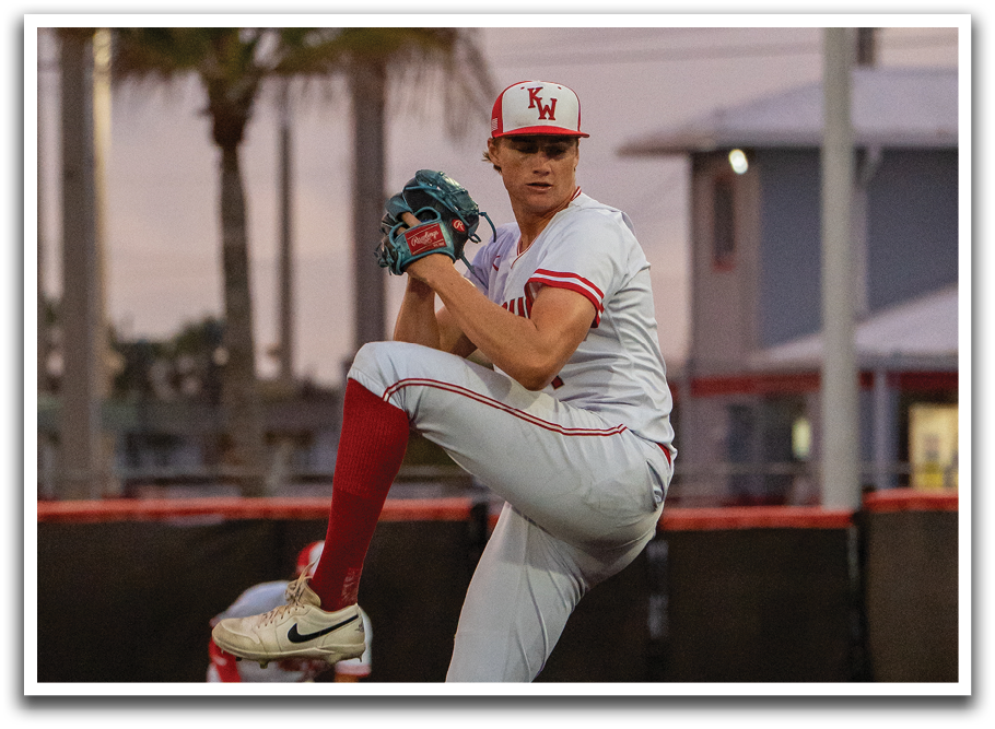 A baseball player in a white uniform is pitching a ball. Description generated by AI
